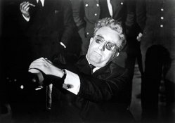 Peter Sellers, as Dr. Strangelove, struggles to control his alien hand.